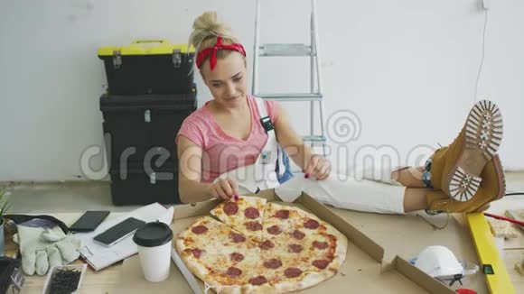 穿工作服的女人在工作场所吃披萨视频的预览图