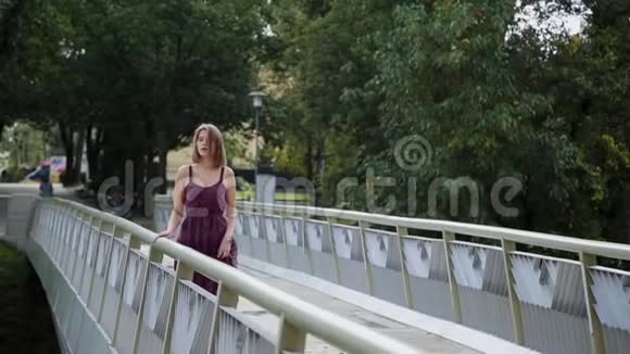 一个非常漂亮的女孩站在桥上望着远处视频的预览图