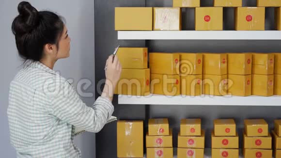 年轻女性企业家在自己的工作中在网上购物数着包裹盒视频的预览图