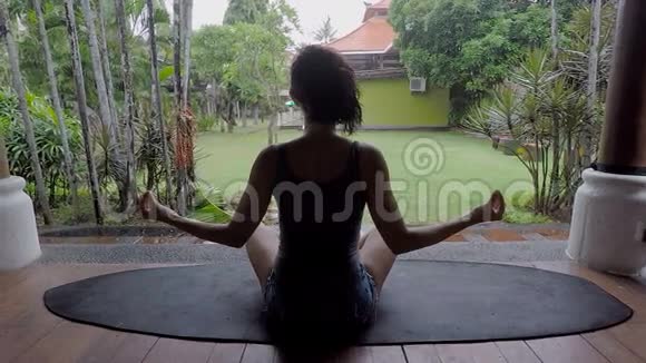 巴厘岛的雨天那个女孩在冥想瑜伽士的姿势黑发女人放松休息一下巴厘岛视频的预览图