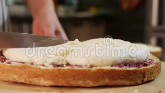 特写女人用刀抚平奶油海绵蛋糕视频的预览图