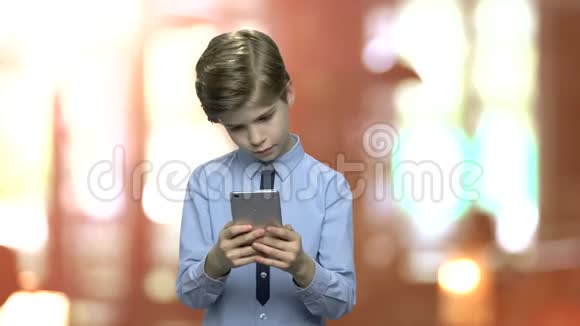 可爱的高加索男孩使用智能手机视频的预览图