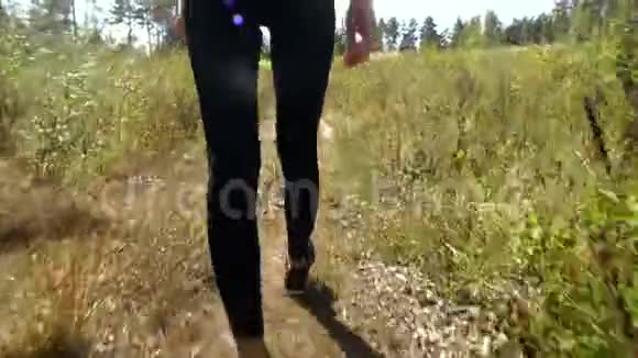 一个女孩走在森林小径上一个运动的爱抚一个背影视频的预览图