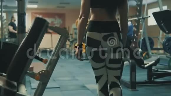 优雅的女士穿过体育健身馆的健身器材视频的预览图