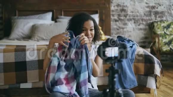 性格开朗的非裔美国少女在家中用dslr相机记录自己的衣柜视频的预览图