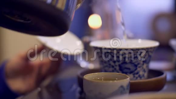 男性手将热水倒入碗中冲泡茶手拿茶杯视频的预览图
