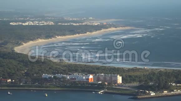 一个美丽的沙滩的顶部景色与蓝色的波浪滚动到海岸一些岩石存在葡萄牙视频的预览图