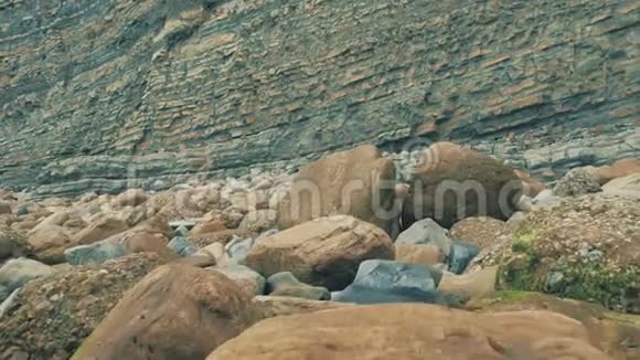 4k大西洋沿岸阴天有不同颜色的岩石橙色的沙子和海浪坎塔布里亚海滨视频的预览图