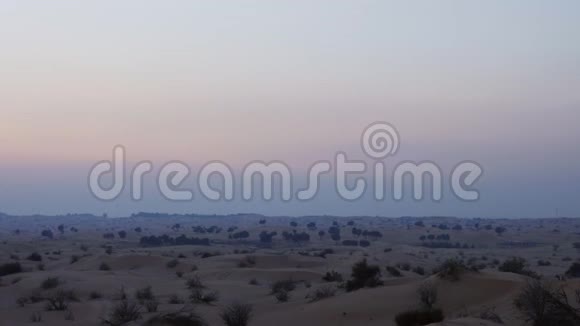 傍晚的天际线和沙漠中的沙丘汽车沿着沙漠行驶视频的预览图