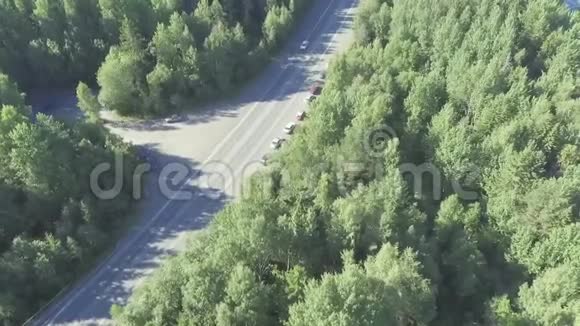 夏季森林公路不饱和的汽车交通鸟瞰图视频的预览图