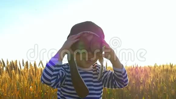 快乐的孩子站在麦田里穿着飞扬的衣服微笑视频的预览图