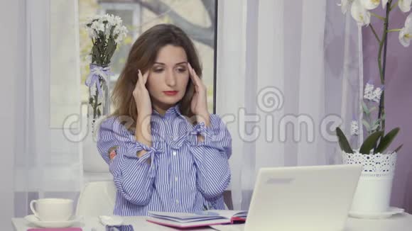 劳累的女人下班后把手提电脑关上视频的预览图