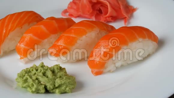 四个大寿司和一块鲑鱼躺在一个大平板上相机左移视频的预览图