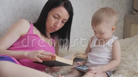 快乐的母亲在室内给孩子读一本书和妈妈一起读书给宝贝的甜蜜时刻视频的预览图