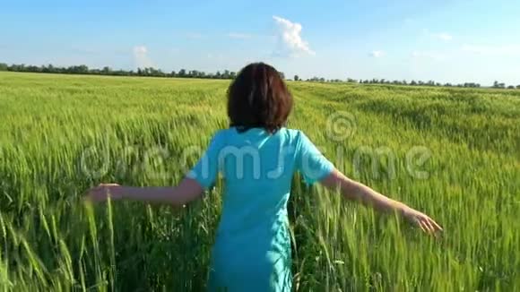 女孩在多云的天空中在麦田上奔跑视频的预览图