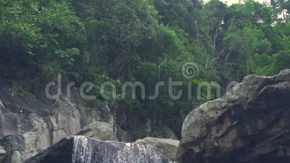 山间瀑布流淌在绿色的热带雨林中热带森林中从山河流出的水流视频的预览图