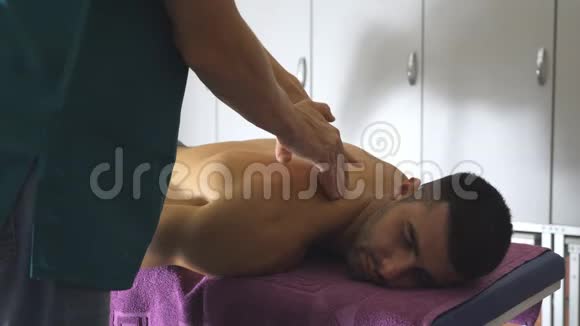 沙龙青年运动员专业按摩肩膀男性手做健康按摩的医生视频的预览图