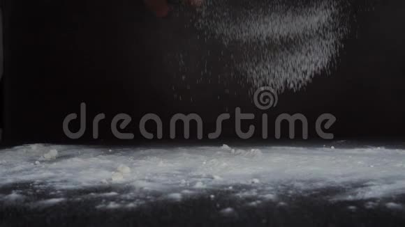 用筛子筛面粉慢镜头拍摄黑色背景隔离从侧面视频的预览图