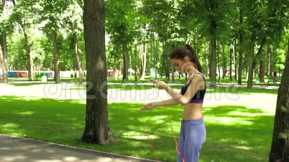 布鲁内特青少年在公园里跳绳视频的预览图