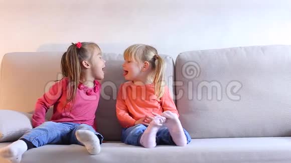 两个小女孩在客厅的沙发上玩得很开心视频的预览图
