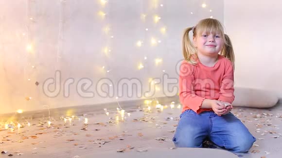 欧洲貌美的小女孩坐在带有新年装饰的照相馆地板上视频的预览图