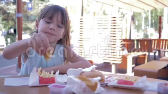街头美食街头咖啡馆里吃快餐的漂亮小女孩视频的预览图