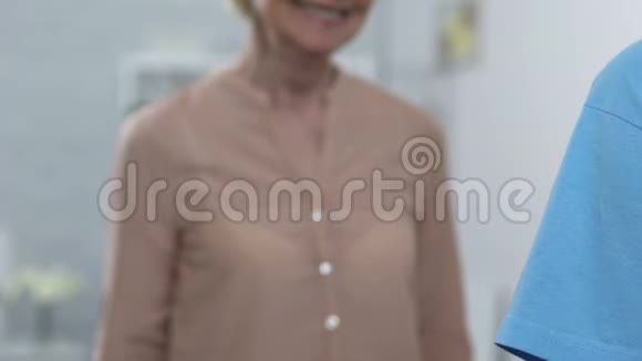 女志愿者在养老院拥抱微笑的老太太给予照顾和支持视频的预览图
