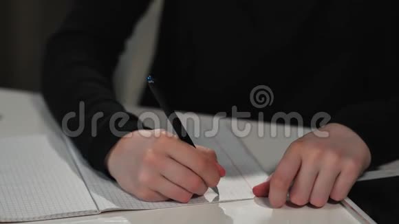 一个快乐的女学生用钢笔在练习本上写字她在做作业特写视频的预览图
