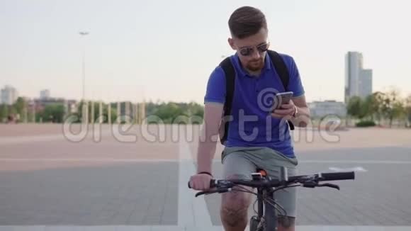 持智能手机骑自行车的嬉皮士视频的预览图