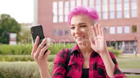 粉红短发女人打视频电话视频的预览图