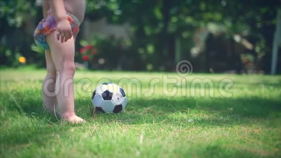 一个两岁的男孩喜欢在公园里踢足球跑步和踢球视频的预览图