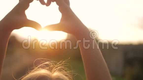 女孩做心手逆天孩子手形成一个心形与日落剪影爱梦夏天视频的预览图