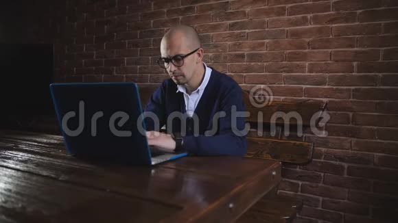 戴眼镜的商人正在笔记本电脑键盘上输入文字自由职业者的工作视频的预览图