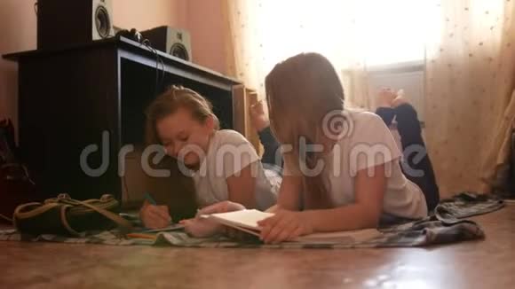 两个十几岁的女孩在家里躺在地上看书画画视频的预览图
