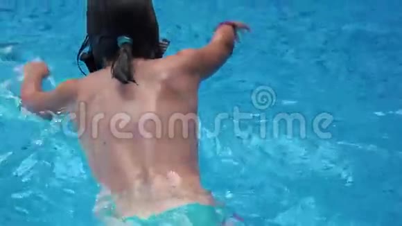 女孩在蓝色的游泳池里游泳视频的预览图