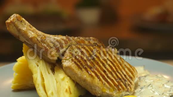 骨头烤烤肉上的牛肉和猪肉肉以及土豆泥和蔬菜在盘子厨房上旋转视频的预览图