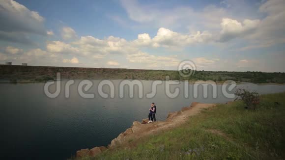 年轻人站在大湖岸上视频的预览图