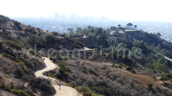 洛杉矶市中心早晨城市景观与格里芬天文台和男子跑下视频的预览图