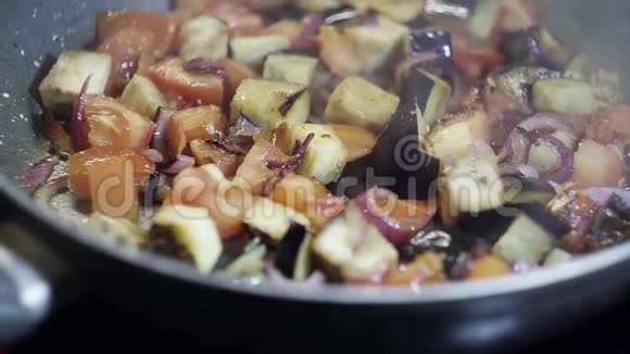 食物准备红西红柿紫葱和茄子在平底锅上炒视频的预览图