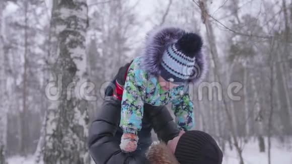 年轻的父亲和他的小儿子在公园里玩把婴儿扔在头顶上方新鲜空气中活跃的游戏视频的预览图