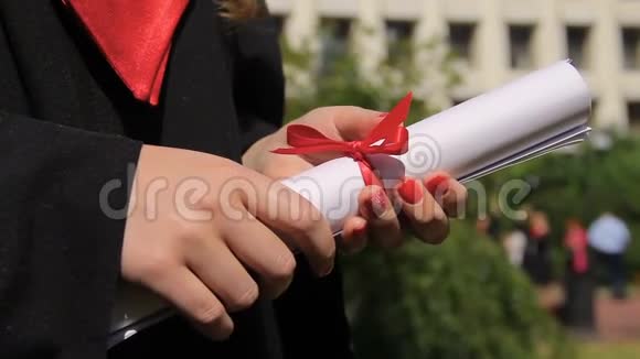 女子双手捧红丝带毕业典礼视频的预览图