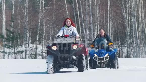 人们穿着冬天的衣服在森林里骑着雪地摩托视频的预览图