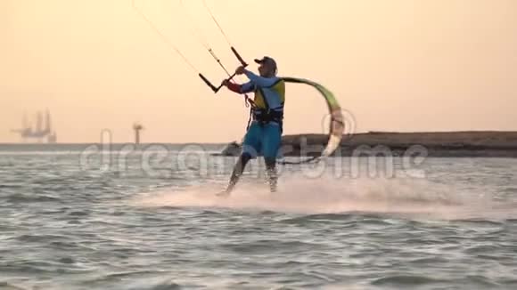 一个人在海上玩风筝在水面上滑行背景上有石油钻井平台视频的预览图