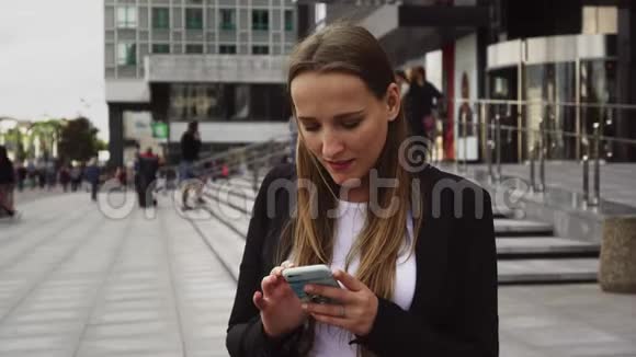 在城市街头使用智能手机的女商人视频的预览图