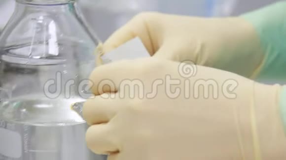 化验员用透明液体贴在瓶子上视频的预览图