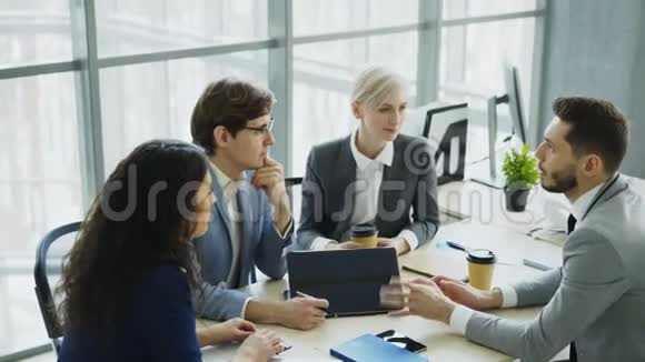 商人与坐在现代办公室的男女同事讨论未来的商业项目视频的预览图