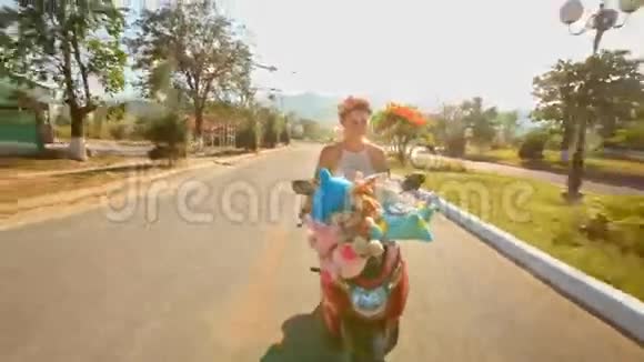 戴花环的女孩骑摩托车沿城市道路疾驰视频的预览图