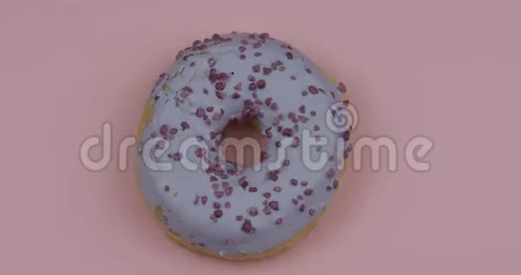 甜甜甜圈在粉红色背景上旋转上景美味新鲜的甜甜圈视频的预览图