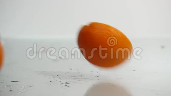 两半的橙色落在白色的背景上白色背景下的鲜橙色特写视频的预览图