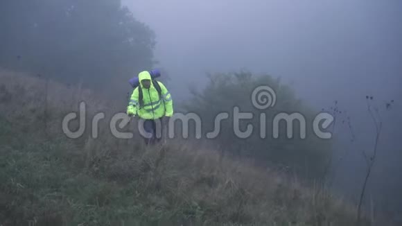 一位背着背包在大雾中独自行走的游客视频的预览图